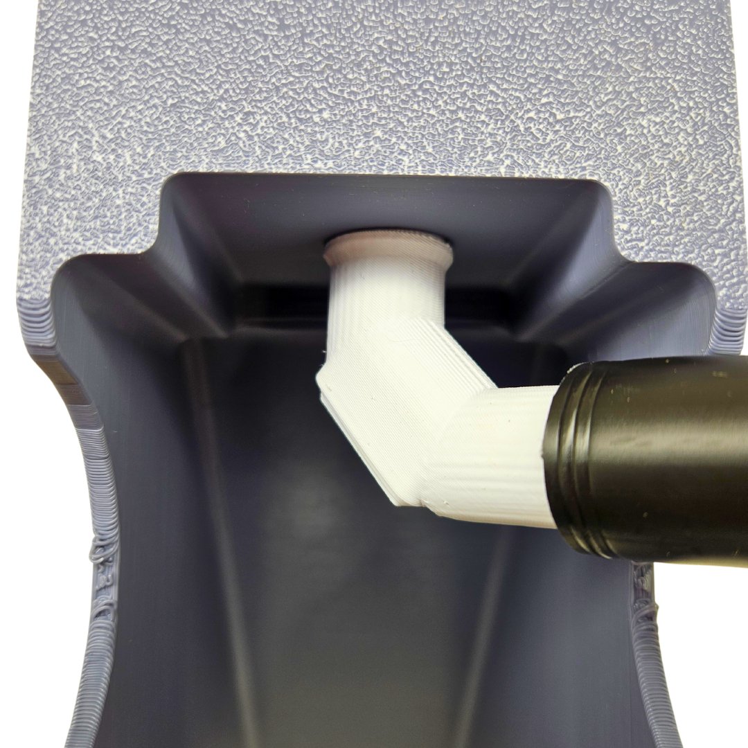 Close-up of a black and white pipe fitting on a textured gray background